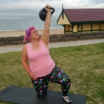 Female doing a kettlebell exercise at the beach