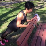 Female doing pushups on bench outdoors