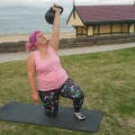 Woman doing kettlebell exercise at the beach